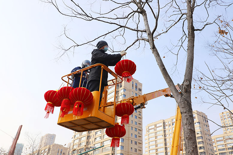 县城管局工作人员悬挂大红灯笼